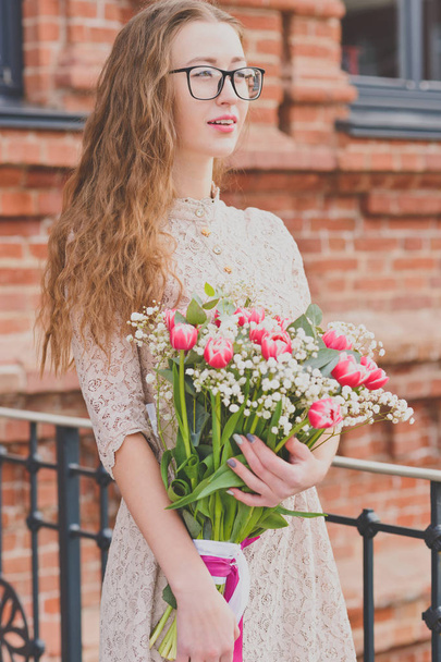 Girl with a big bouquet of tulips - Фото, изображение