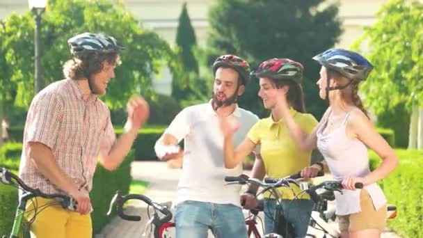 Ryhmä onnellisia pyöräilijöitä hauskaa puistossa
. - Materiaali, video