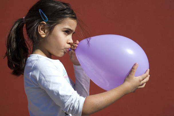 Girl blowing up balloon - Photo, Image