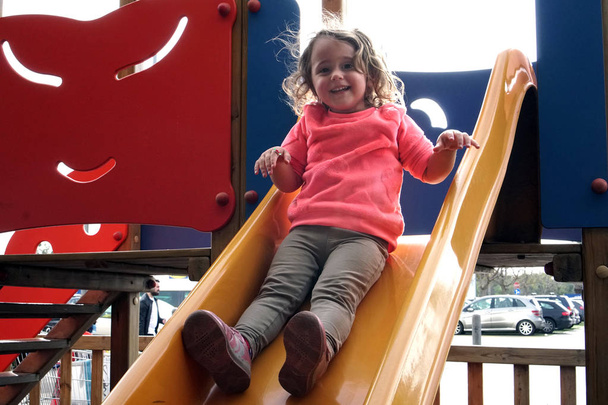 the girl is riding on a children's slide - Photo, Image
