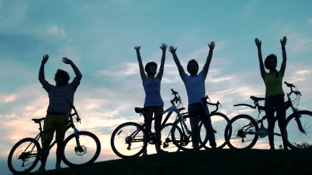 Jonge vrienden met fietsen op de hemelachtergrond. - Video