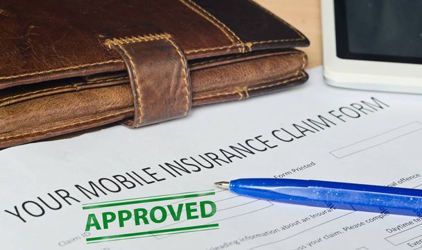 your mobile insurance claim form on a wooden surface.  - Photo, Image