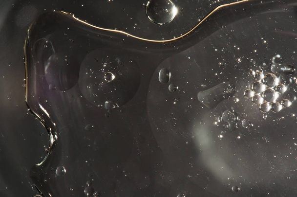 drops of water on the surface of the oil, variation of dissimilar liquids, macro abstract background - Foto, afbeelding