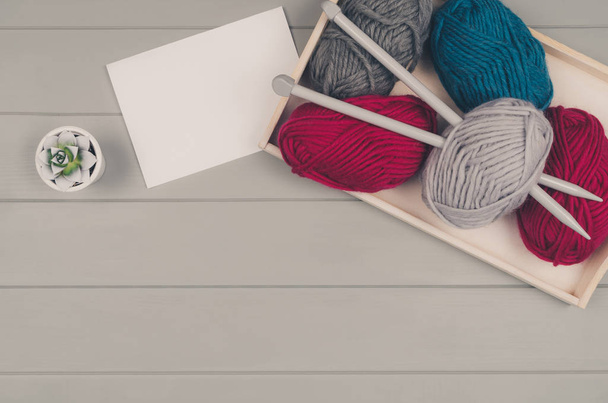 Knitting background with wool and needles on gray wooden table - Fotografie, Obrázek