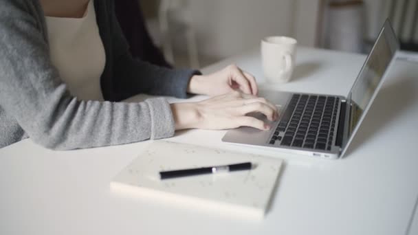 Жінка набирає руки на клавіатурному ноутбуці, сидячи за столом
 - Кадри, відео