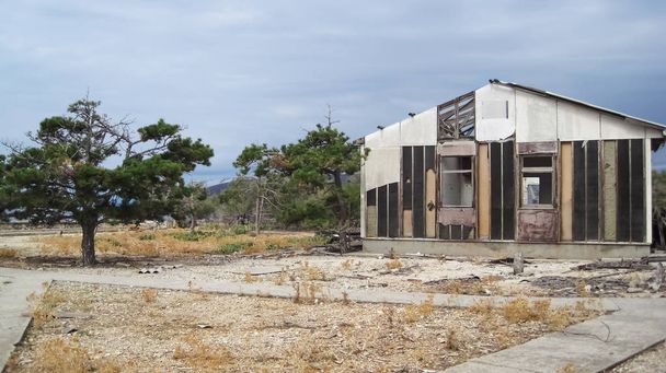Un viejo almacén en ruinas en la isla desnuda en un día nublado en verano
 - Foto, Imagen