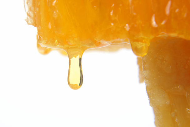 miel que fluye de los panales sobre un fondo claro
 - Foto, imagen