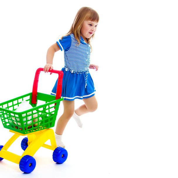 Little girl with a cart in the supermarket. - Fotoğraf, Görsel
