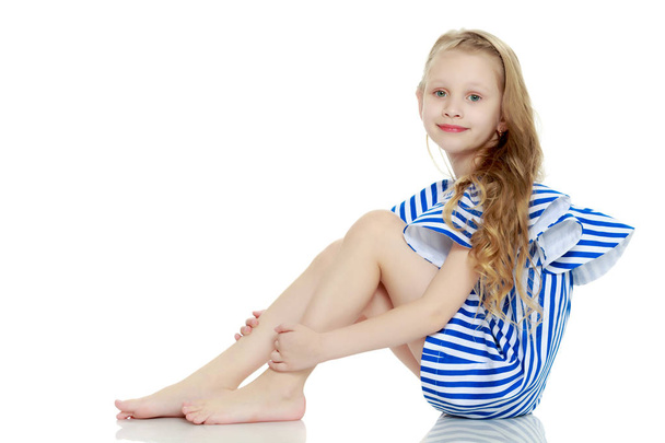 Adorable little blond girl in very short summer striped dress. - Φωτογραφία, εικόνα