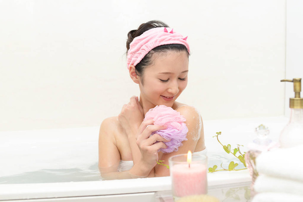 Jovem bela mulher tomando banho relaxante
 - Foto, Imagem
