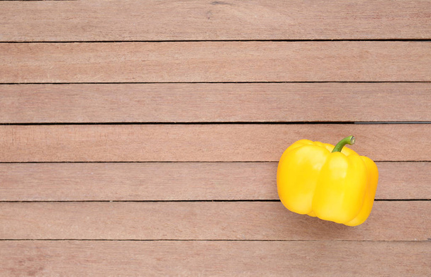 Yellow bell pepper with copy space on wood background. - Valokuva, kuva