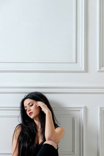 brunette valkoihoinen tyttö musta rento tyyli vaatteita istuu
 - Valokuva, kuva