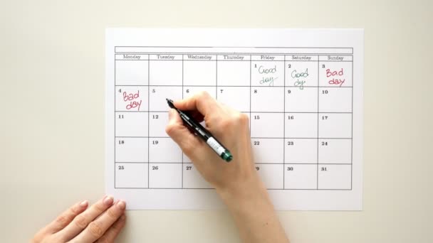 Podepsat den v kalendáři s perem, nakreslit dobrý špatný den - Záběry, video