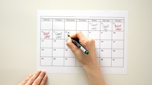 Podepsat den v kalendáři s perem, nakreslit dobrý špatný den - Záběry, video