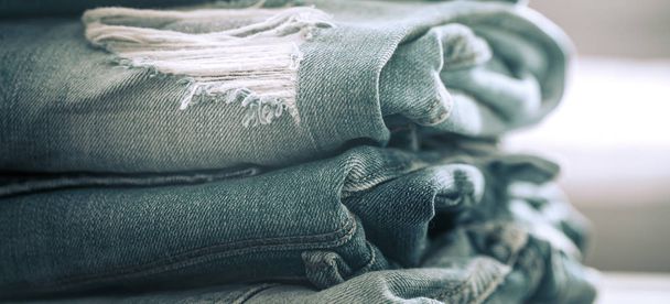 A stack of jeans on a wooden background - Valokuva, kuva