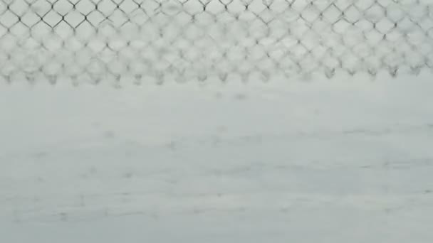 Ο φράχτης από συρματόπλεγμα αντανακλάται σε μια λιμνούλα το ηλιοβασίλεμα - Πλάνα, βίντεο