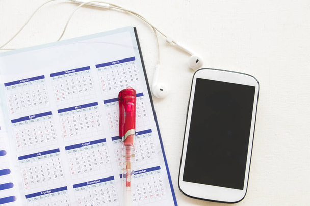 calendario de planificador de cuadernos con teléfono móvil para negocios en el escritorio de oficina
 - Foto, imagen