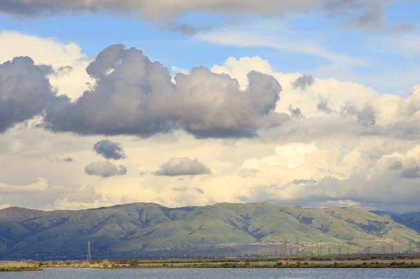 Бушующие облака покидают залив над хребтом Дьябло. Вид из Shoreline Park, округ Санта-Клара, Калифорния, США
. - Фото, изображение