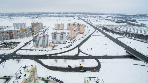 Cidade de inverno de uma altura. Foto tirada por quadrocopter. Grandes edifícios altos e estrada
 - Foto, Imagem
