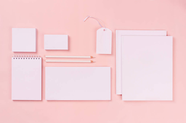 Modern minimalistic workspace with white blank stationery on soft pastel pink background, top view. - Фото, зображення