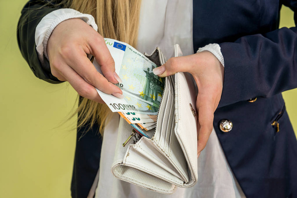 Nainen ottaa euroseteleitä lompakosta vihreällä
 - Valokuva, kuva