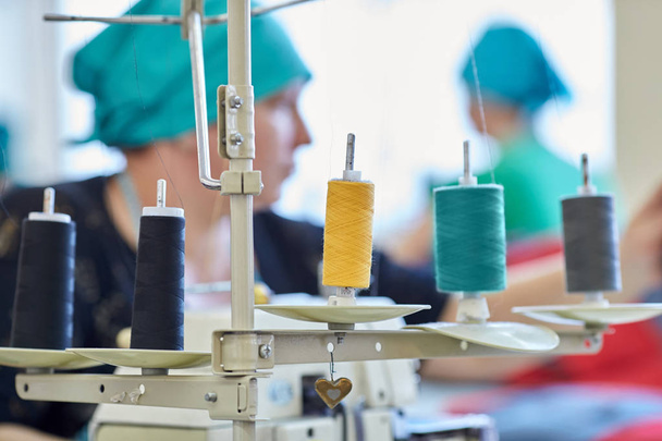 Rodillos con rosca de color en la máquina de coser en la costura
  - Foto, imagen