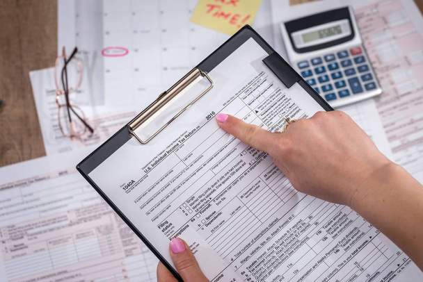 Mujer de negocios llenando formulario de impuestos. 2017. Concepto financiero
. - Foto, imagen