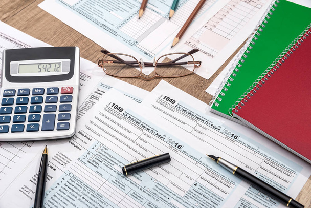 formulario de impuestos con bloc de notas, pluma, lápiz y calculadora
 - Foto, imagen