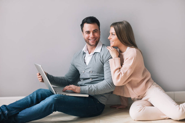 Cheerful couple with laptop at home. - Foto, afbeelding