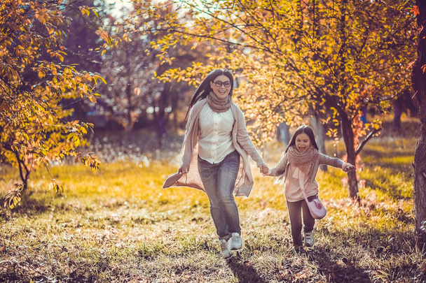 Happy mum and the daughter play autumn park - Foto, immagini