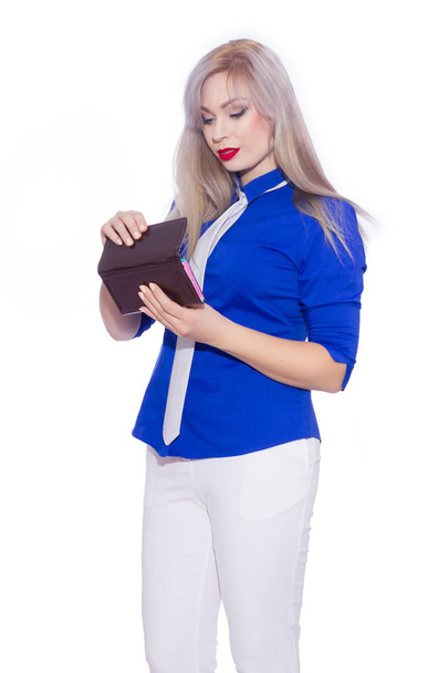 studio isolated portrait of a young blond woman in white trouser suit. The girl is holding a purse. - Фото, изображение