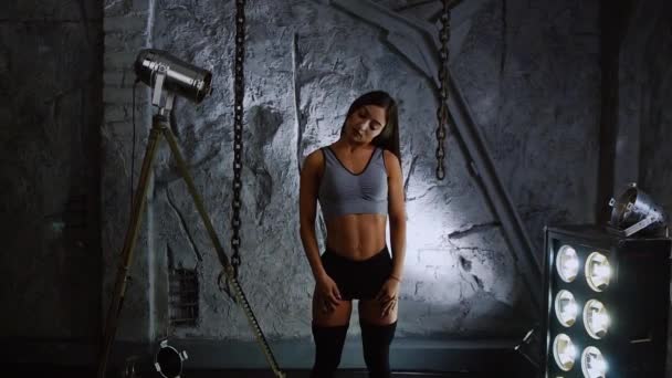 Λεπτός φουσκωμένα όμορφη γυναίκα αθλητής στο φόντο του πέτρινους τοίχους συμπεριφοράς προθέρμανσης το λαιμό σας πριν από την κατάρτιση. - Πλάνα, βίντεο