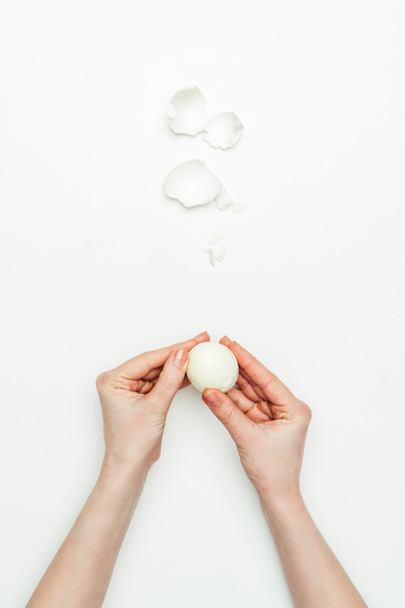cropped image of woman peeling cooked egg isolated on white - Fotografie, Obrázek