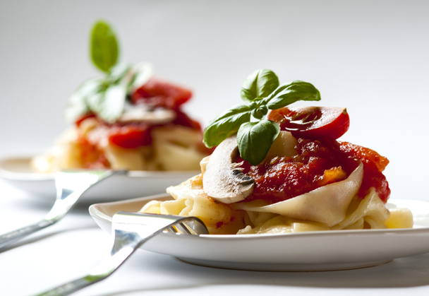 Pastas italianas con salsa de tomate y setas
 - Foto, imagen