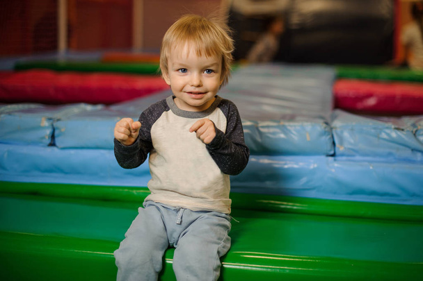Cute little smiling boy sitting on the trampoline - Foto, afbeelding