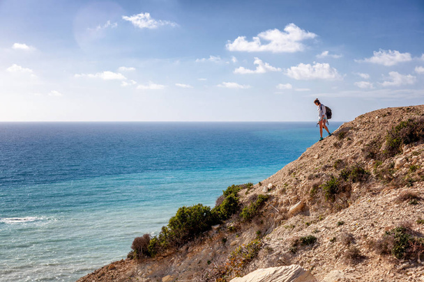 Genç kadın Gezgin deniz, arka planda bir kayaya dışarı - Fotoğraf, Görsel