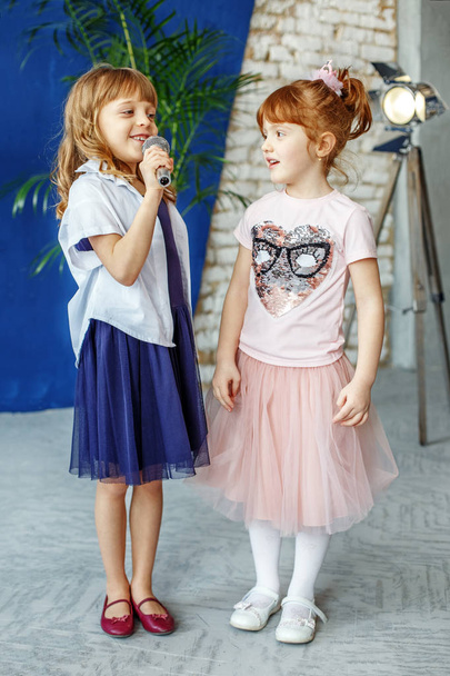 Two young children sing a song on a microphone. Group. The conce - Photo, Image