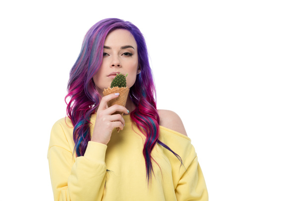 Beautiful young woman with purple hair holding cactus plant in ice cream waffle cone isolated on white - Photo, Image