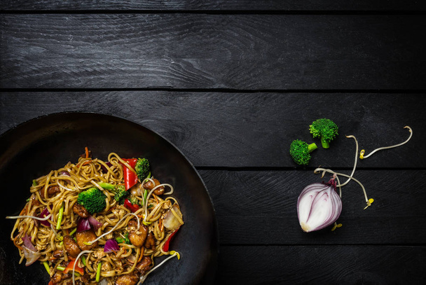 Рух Фрай локшина у традиційних китайських wok з інгредієнтами. Місце для тексту. - Фото, зображення