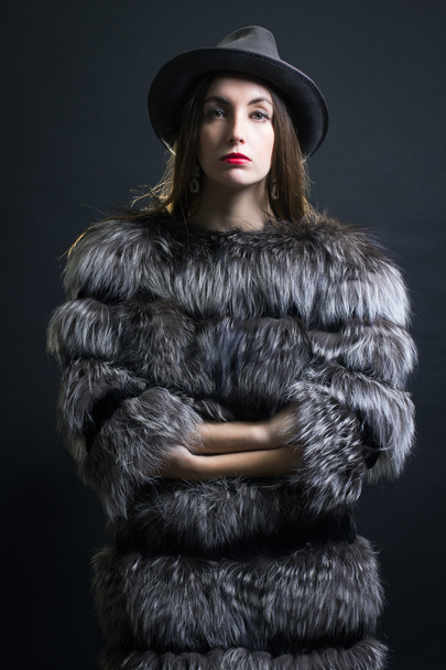 Mujer joven en un abrigo de piel y sombrero
. - Foto, imagen