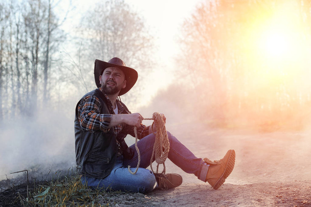 Un uomo indossa un cappello da cowboy e un loso sul campo. Americano
  - Foto, immagini