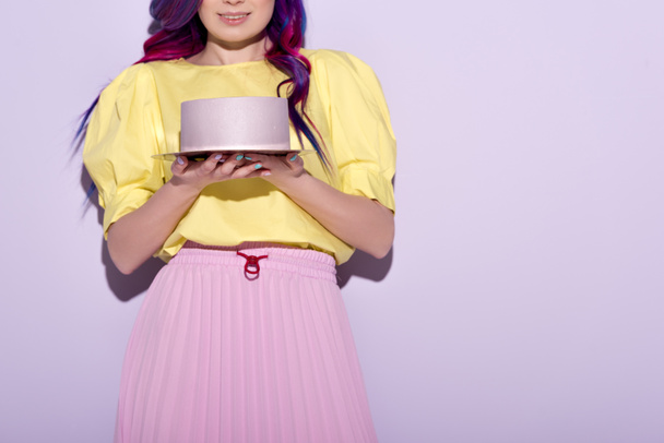 обрізаний знімок усміхненої жінки з барвистим волоссям, що тримає торт на день народження
 - Фото, зображення
