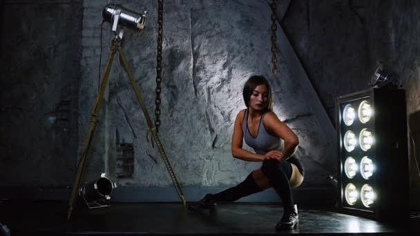 Sport sexy dívka v krátké šortky prohřívá svaly nohou a hýždí před zahájením tréninku. - Záběry, video