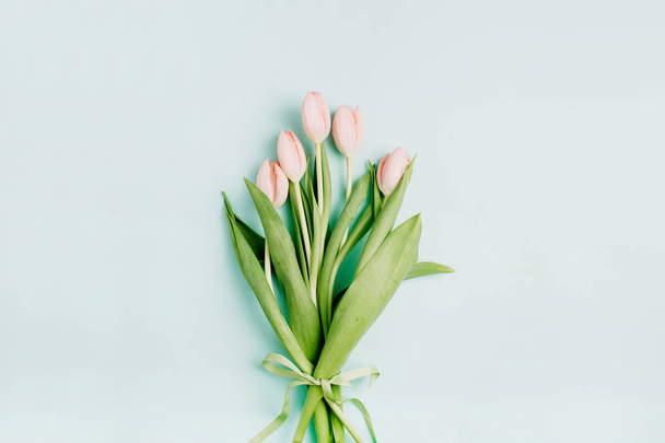 Розовый букет цветов тюльпана на бледно-голубом фоне. Квартира лежала, вид сверху. Весенний цветочный концепт
. - Фото, изображение