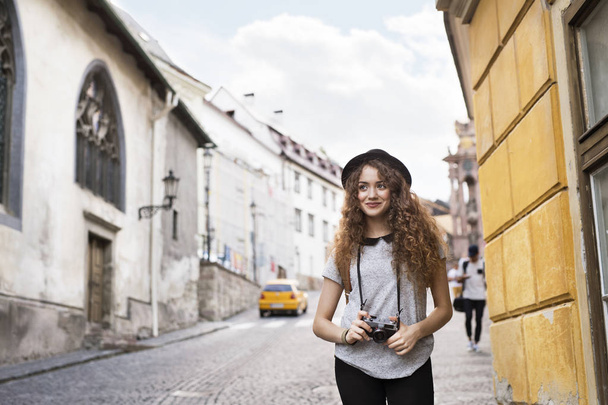 Beautiful young tourist with camera in the old town. - Zdjęcie, obraz
