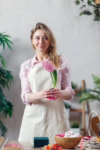 Picture of florist woman in apron at room with flowers - Foto, Imagem