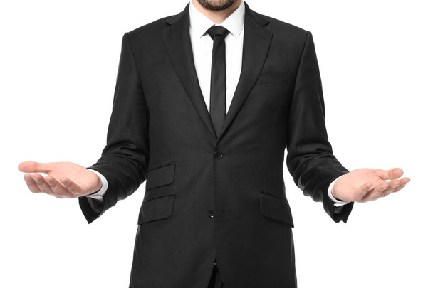 Young businessman showing balance gesture on white background - Photo, Image