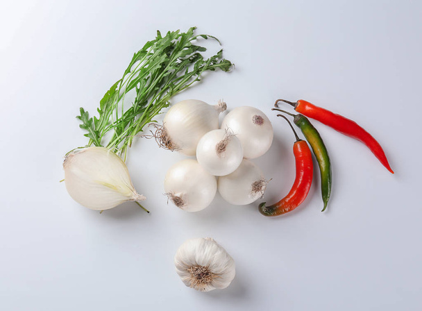 Onions, garlic, arugula and chili peppers on white background, top view - Fotoğraf, Görsel