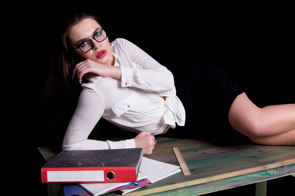 сексуальний вчитель позує на столі в студії на чорному тлі
 - Фото, зображення
