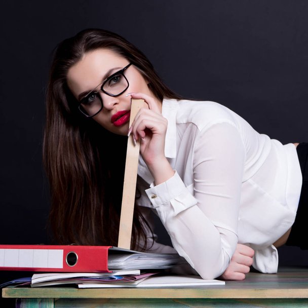 sexy profesora posando en escritorio en estudio sobre fondo negro
 - Foto, imagen